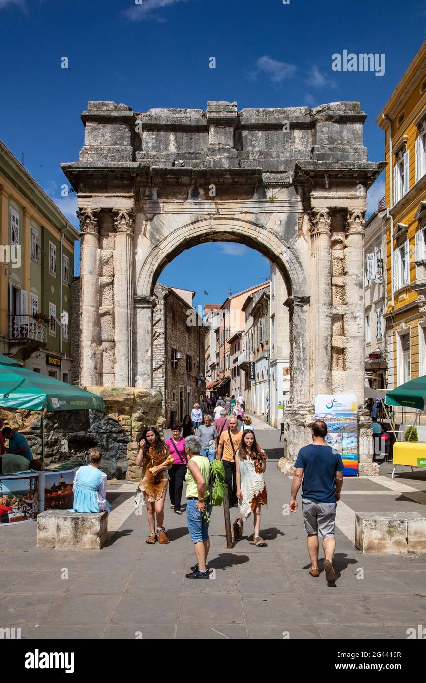 Piétons et l'ancienne arche romaine du Sergii dans le centre de la vieille ville, Pula, Istrie, Croatie, Europe Banque D'Images