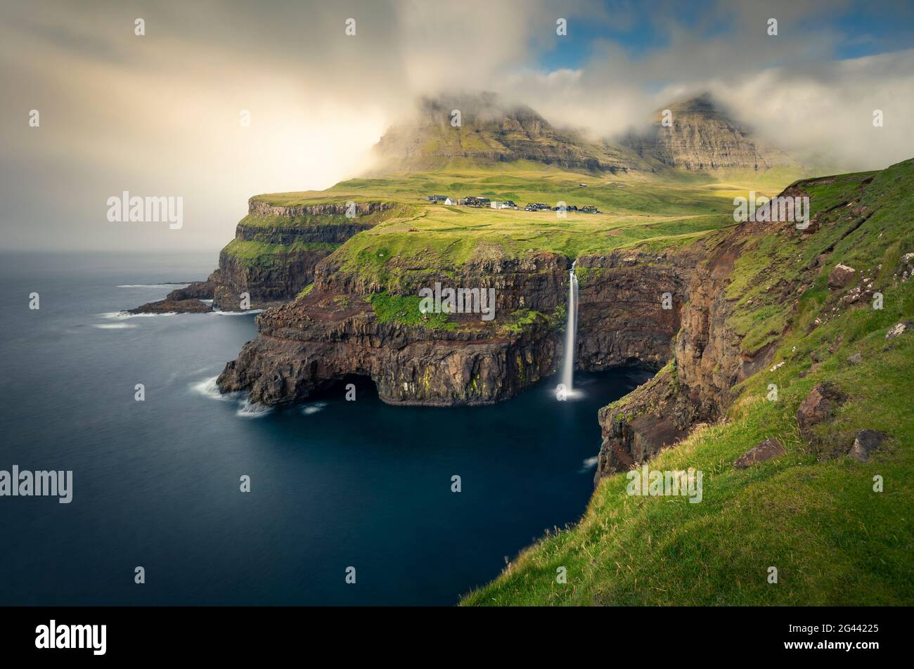Cascade de Múlafossur avec village de Gásadalur sur l'île de Vagar, îles Féroé Banque D'Images