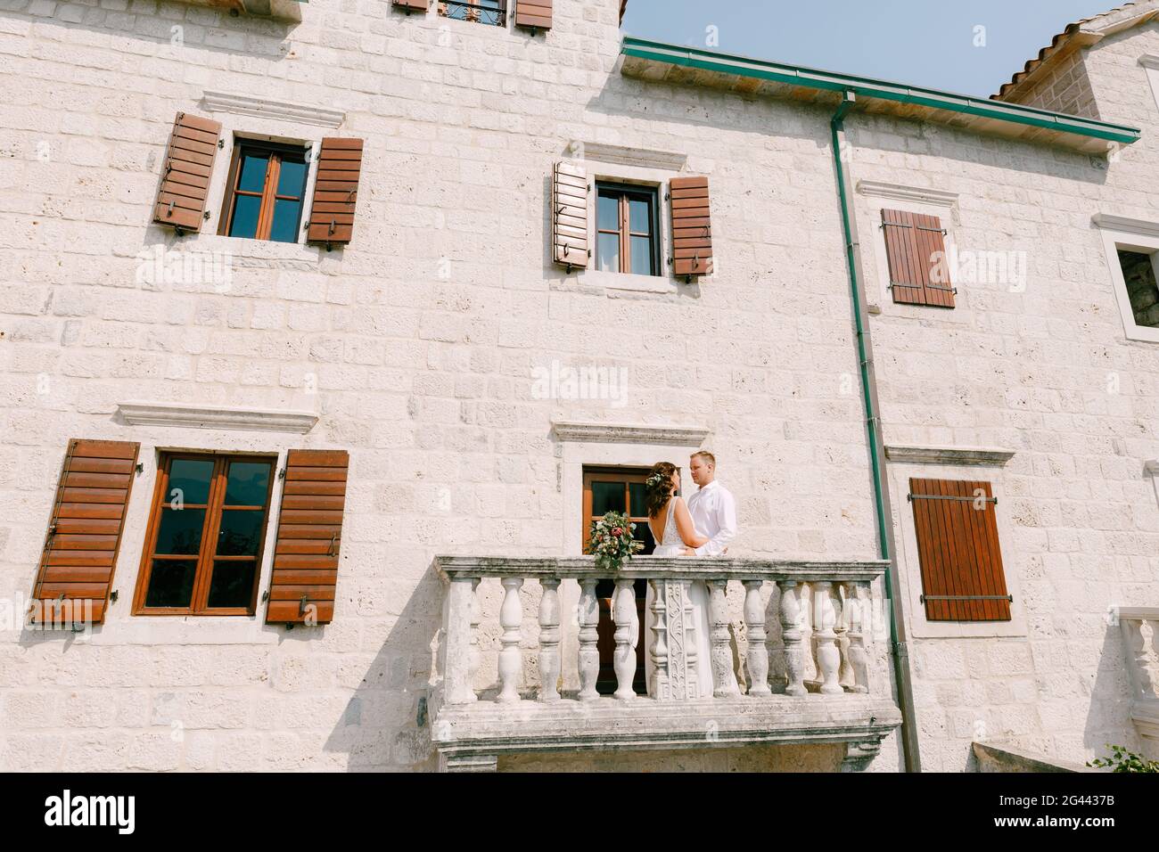 La mariée et le marié embrassent sur le grand balcon de Un ancien bâtiment dans la ville ancienne du Monténégro Banque D'Images