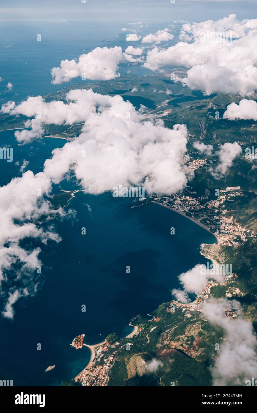 Vue depuis la fenêtre de l'avion sur la côte du Monténégro à travers les cumulus blancs Banque D'Images