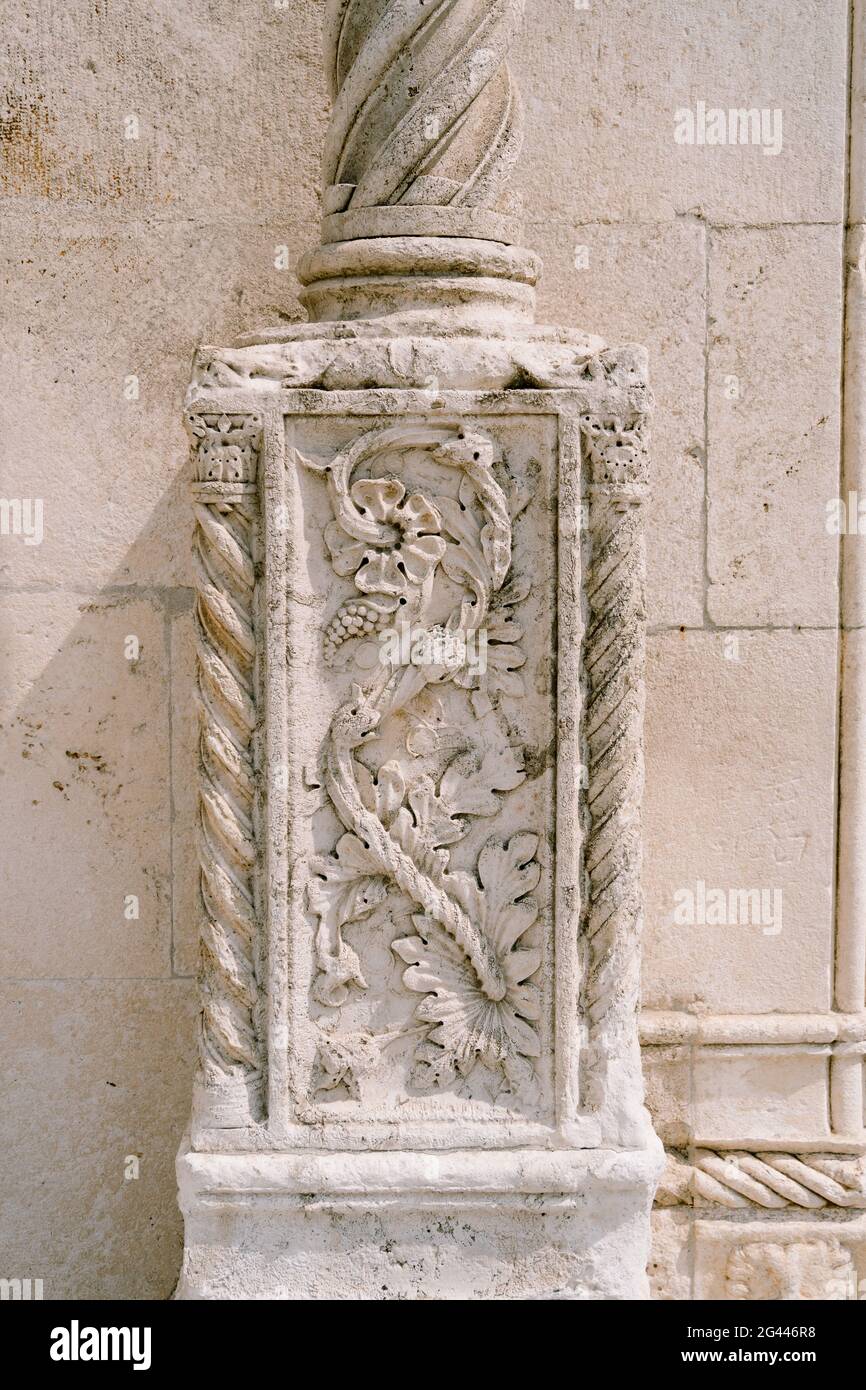 Mur en pierre avec un bas-relief en forme de fleur sur une colonne. Banque D'Images