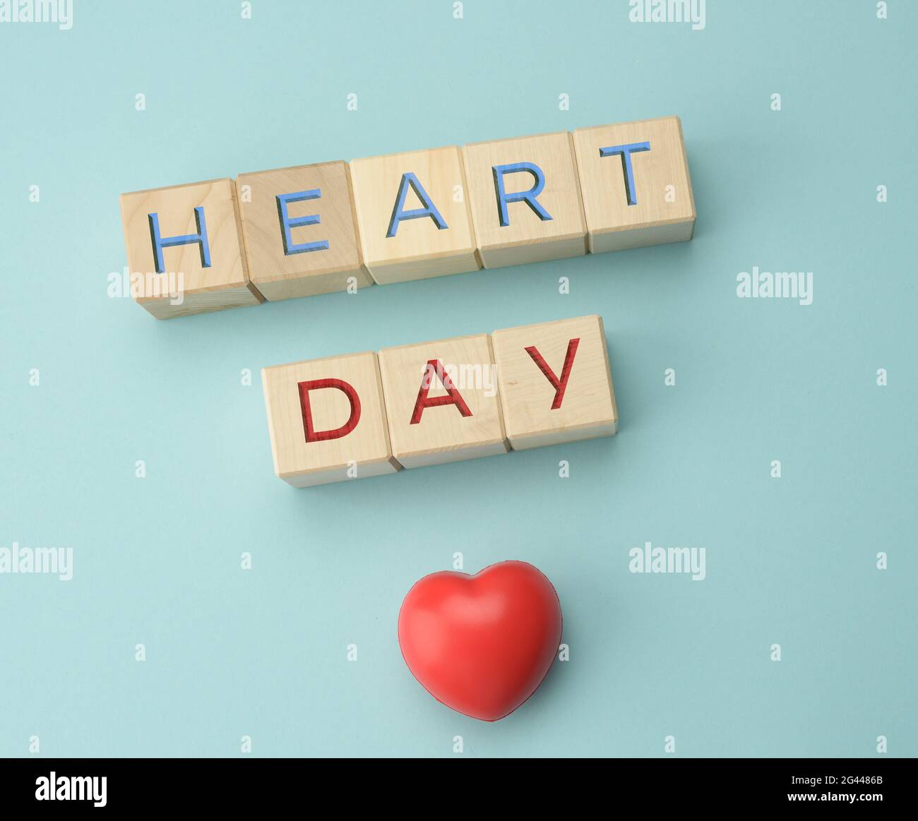 Blocs en bois avec inscription Heart Day sur fond bleu. Concept de soins de santé, contrôle annuel des organes humains Banque D'Images