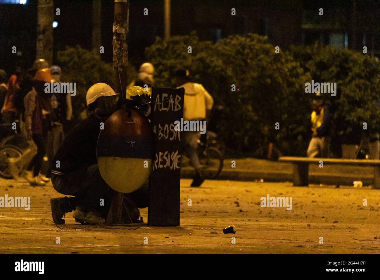 Bogota, Colombie. 17 juin 2021. Des membres de la ligne de front avec des boucliers avec le drapeau colombien se tiennent devant les manifestants tandis que les actes culturels et les manifestations se sont intensifiés plus tard dans la nuit à des affrontements entre manifestants et la police anti-émeute colombienne (ESMAD) protestent contre le président Ivan Duque, le 17 juin 2021 à Bogota, en Colombie. Crédit : long Visual Press/Alamy Live News Banque D'Images