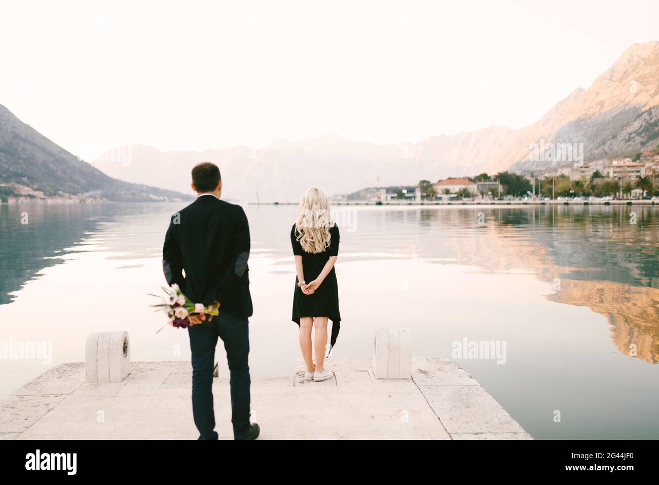 L'homme est sur le point de surprendre sa petite amie avec un bouquet de fleurs et une proposition de mariage Banque D'Images