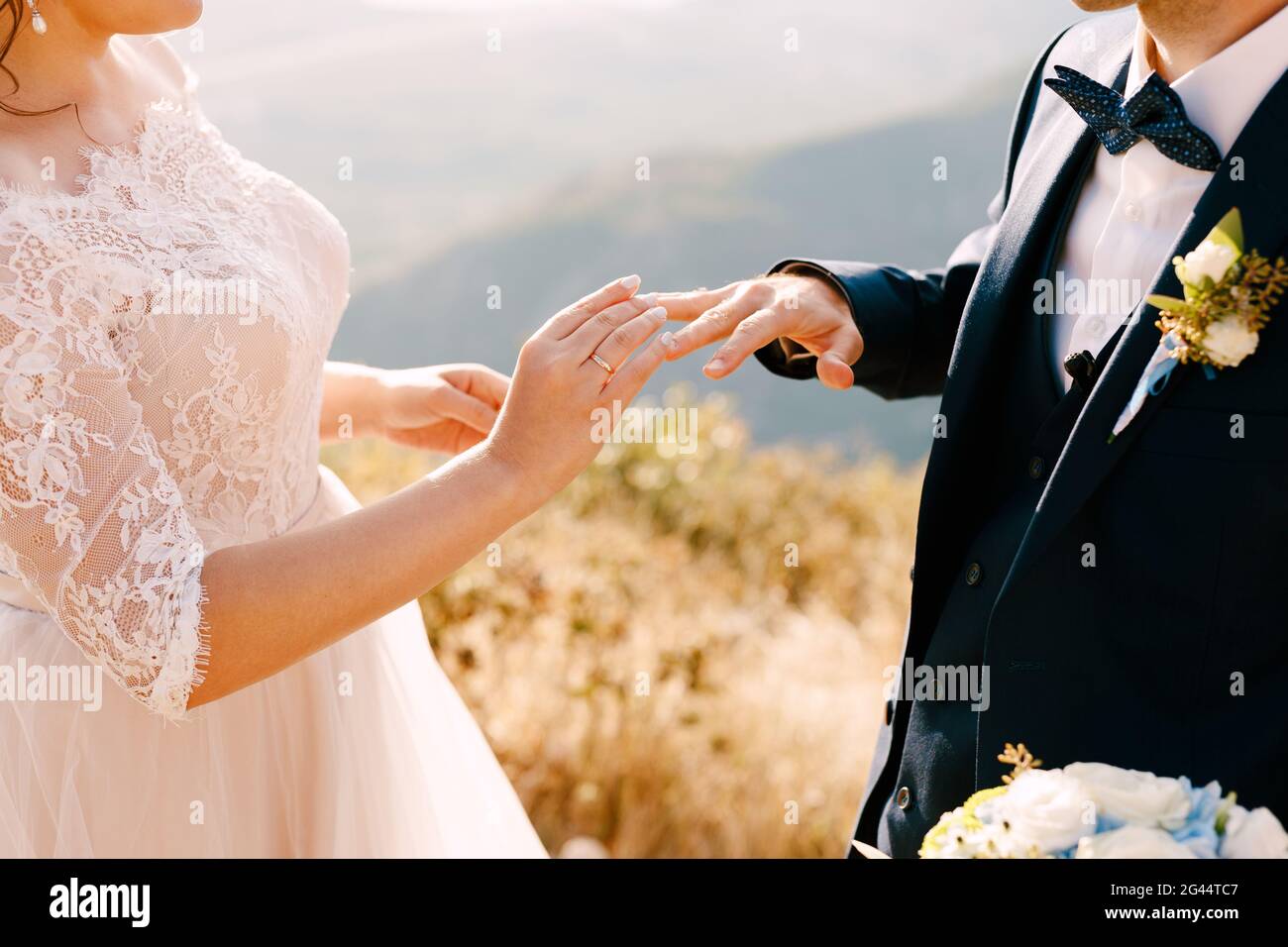 Mariée dans une belle robe met un anneau sur le le doigt du marié Banque D'Images