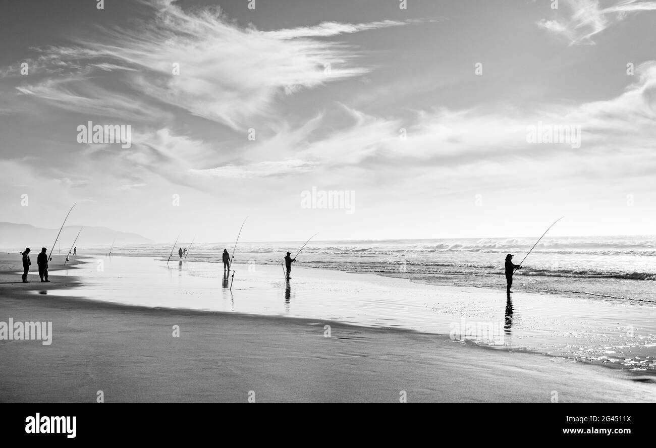 Groupe de pêcheurs sur la plage en noir et blanc Banque D'Images