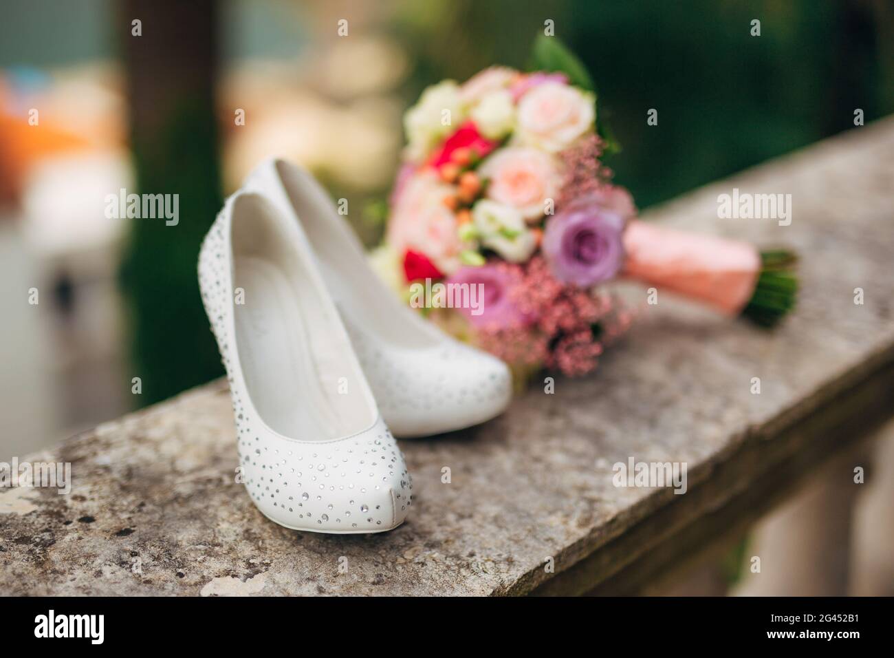 Les chaussures de mariée reposent sur l'herbe verte Banque D'Images