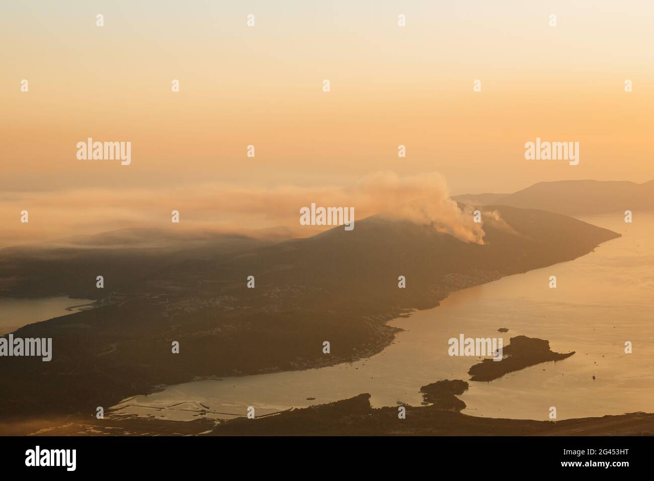 Une colonne de fumée sur la péninsule de Lustica au Monténégro. Les feux de forêt font rage au coucher du soleil. Banque D'Images