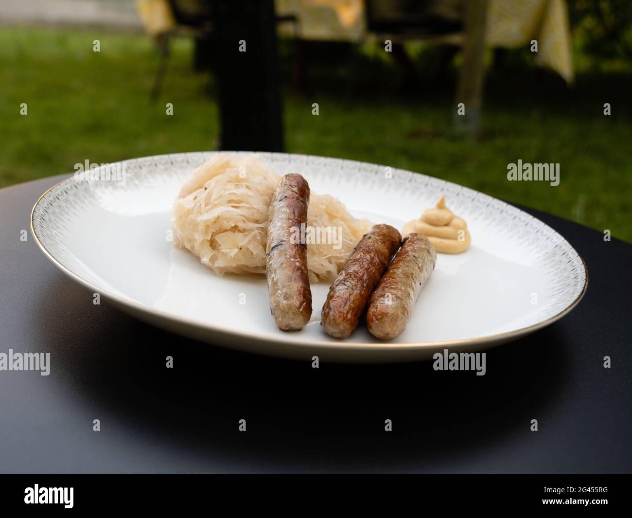 Nuremberg saucisse grillée ou Nürnberger Rostbratwurst à la sauce ou à la sauce Cabbage et à la moutarde sur une assiette blanche en plein air Banque D'Images