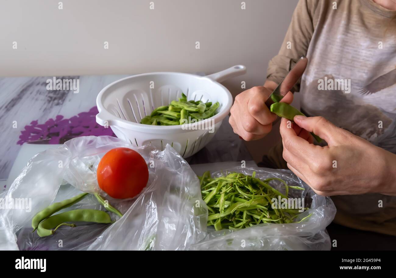 Haricots verts. Femme cuisine dans la cuisine à la maison Banque D'Images