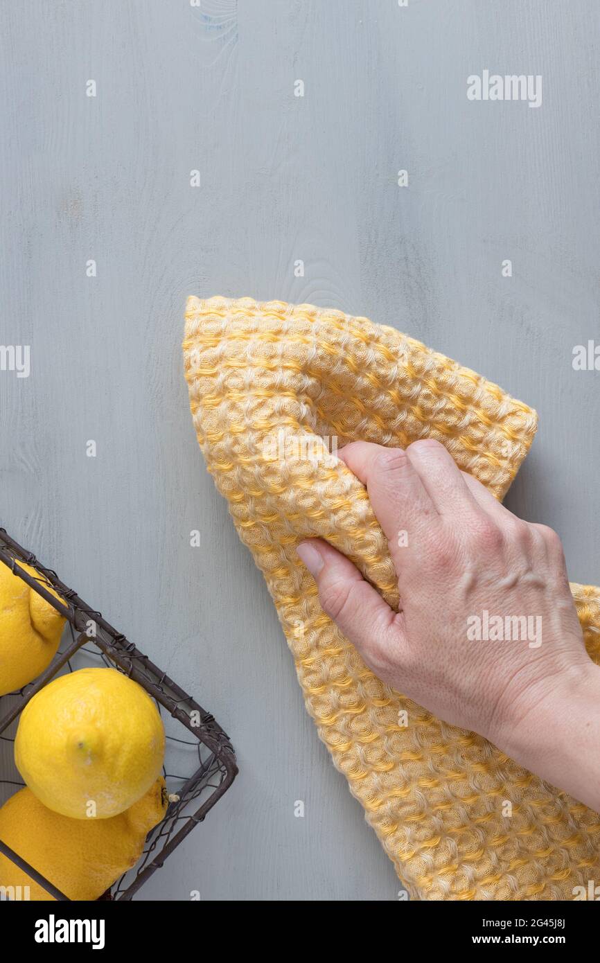 Femme préparant à la main ta jaune et gris scène sur une table rustique en bois. Banque D'Images