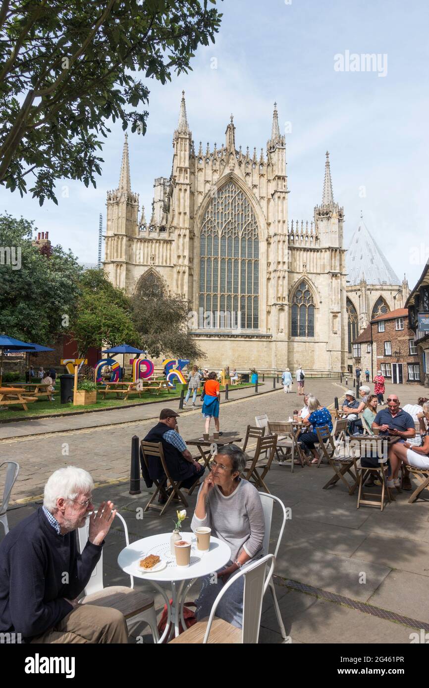 Les personnes qui mangent à l'extérieur avec York Minster en arrière-plan, City of York, Yorkshire, Angleterre, Royaume-Uni Banque D'Images