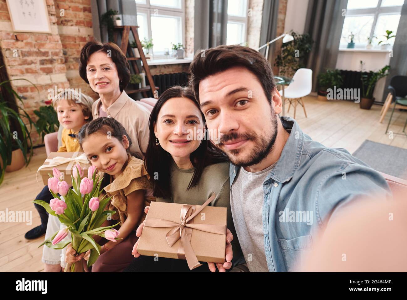 Homme barbu faisant le selfie avec sa famille dans le salon Banque D'Images