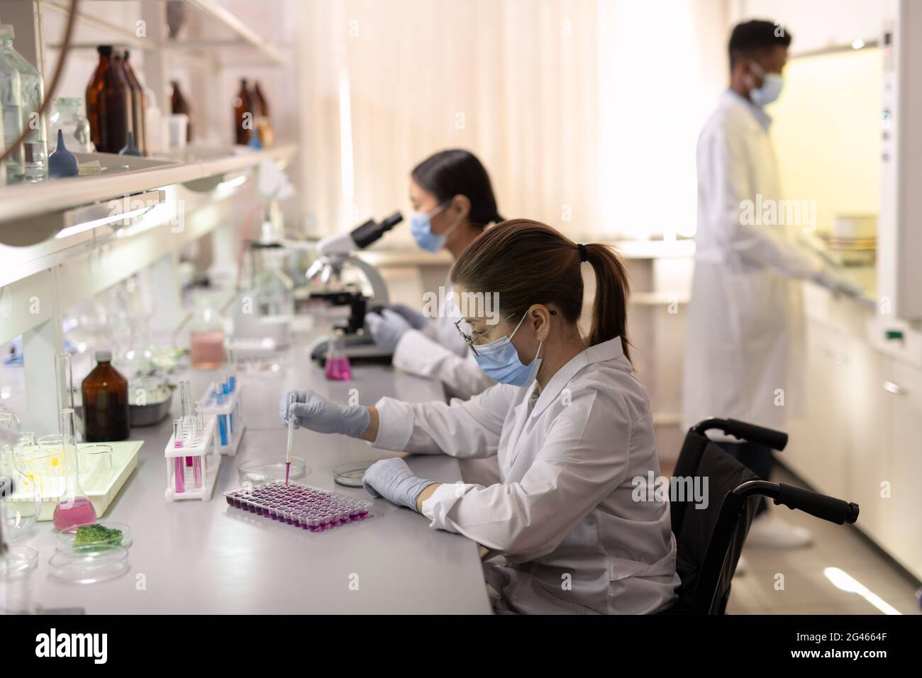 Groupe de scientifiques contemporains en Whitecavoine travaillant en laboratoire Banque D'Images
