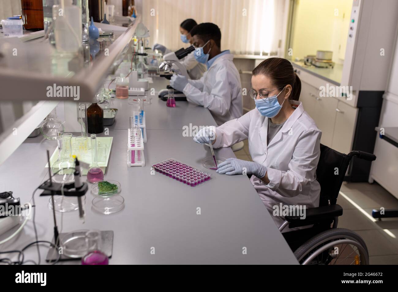 Femme chimiste travaillant avec des substances liquides en laboratoire Banque D'Images