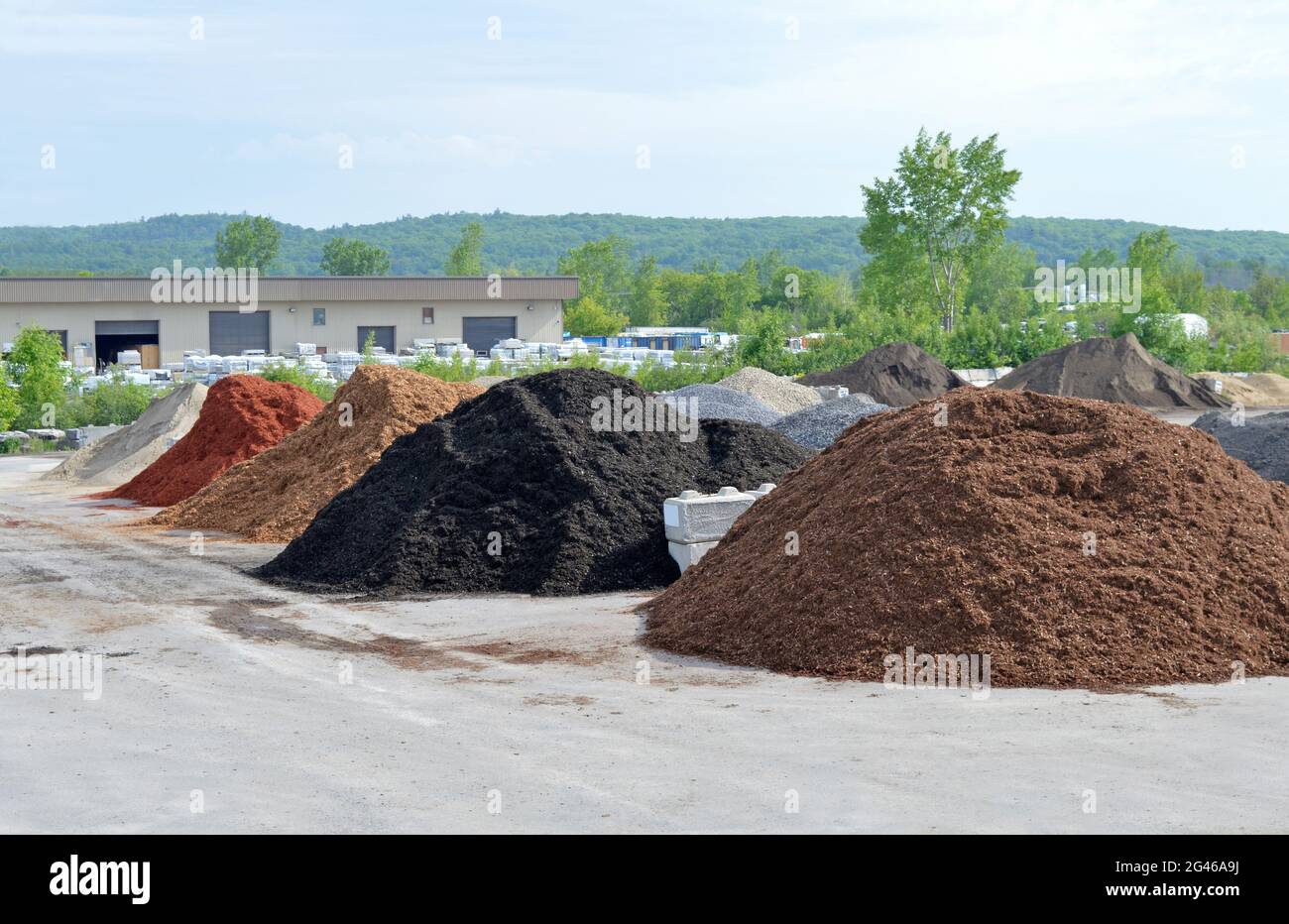 plusieurs piles de paillis de pierre et de cèdre se sont séparées en différents types pour l'emballage dans l'entrepôt vu à l'arrière. Banque D'Images