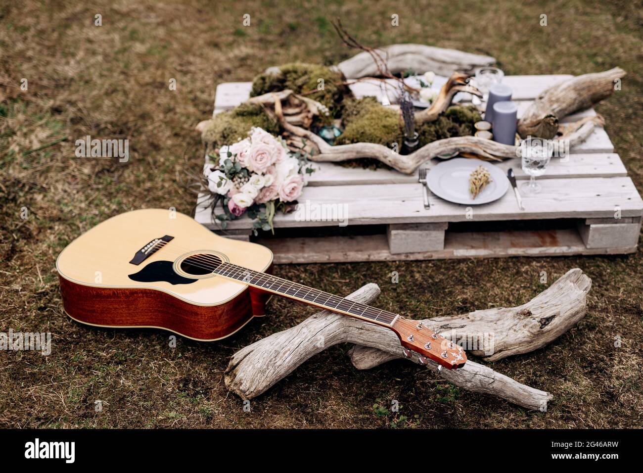 Guitare acoustique sur l'herbe sur le fond d'un stand en bois avec des articles de décoration. Banque D'Images