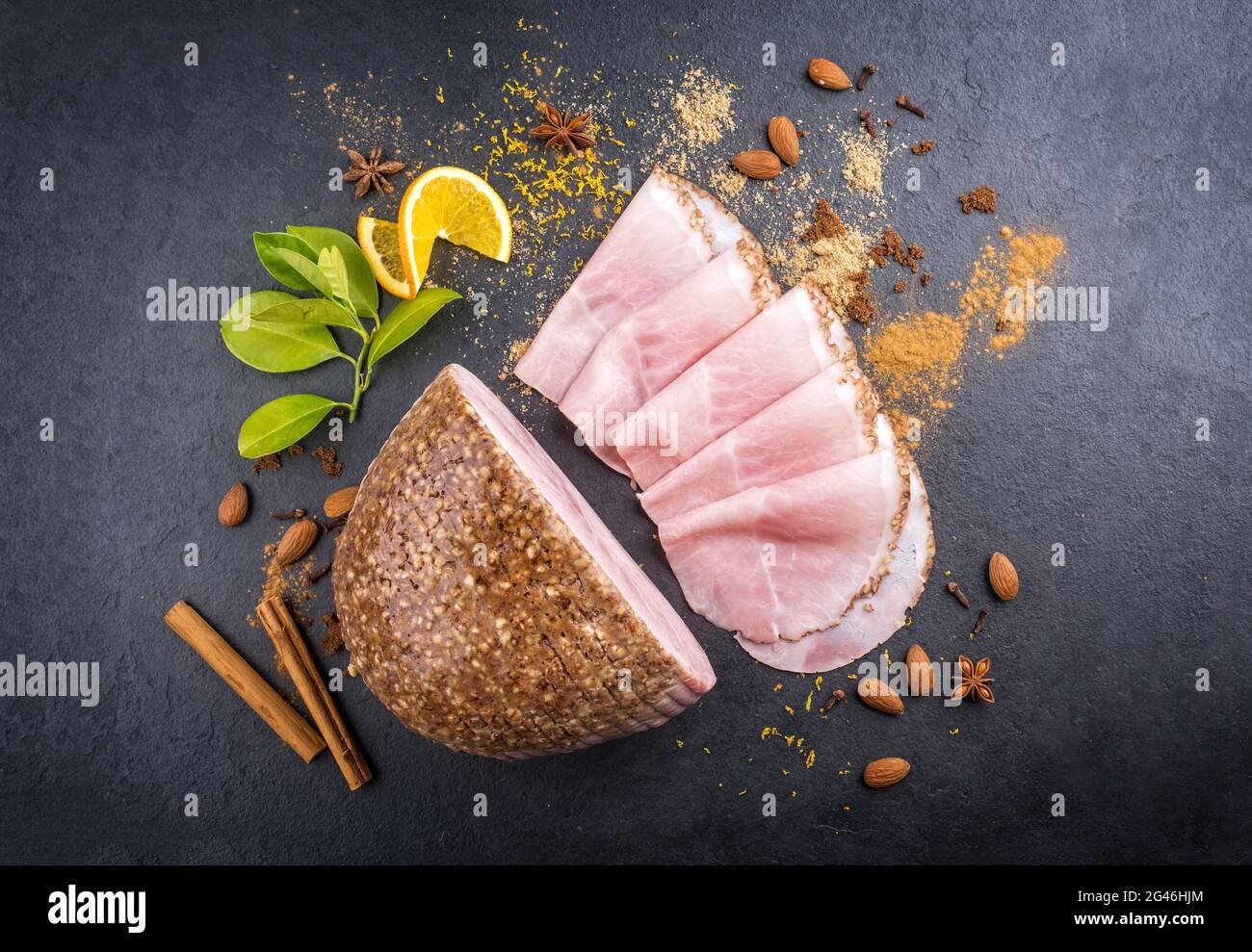 Le jambon de Noël traditionnel allemand de style moderne aux épices exotiques et à l'orange est offert comme vue de dessus sur un tableau noir Banque D'Images