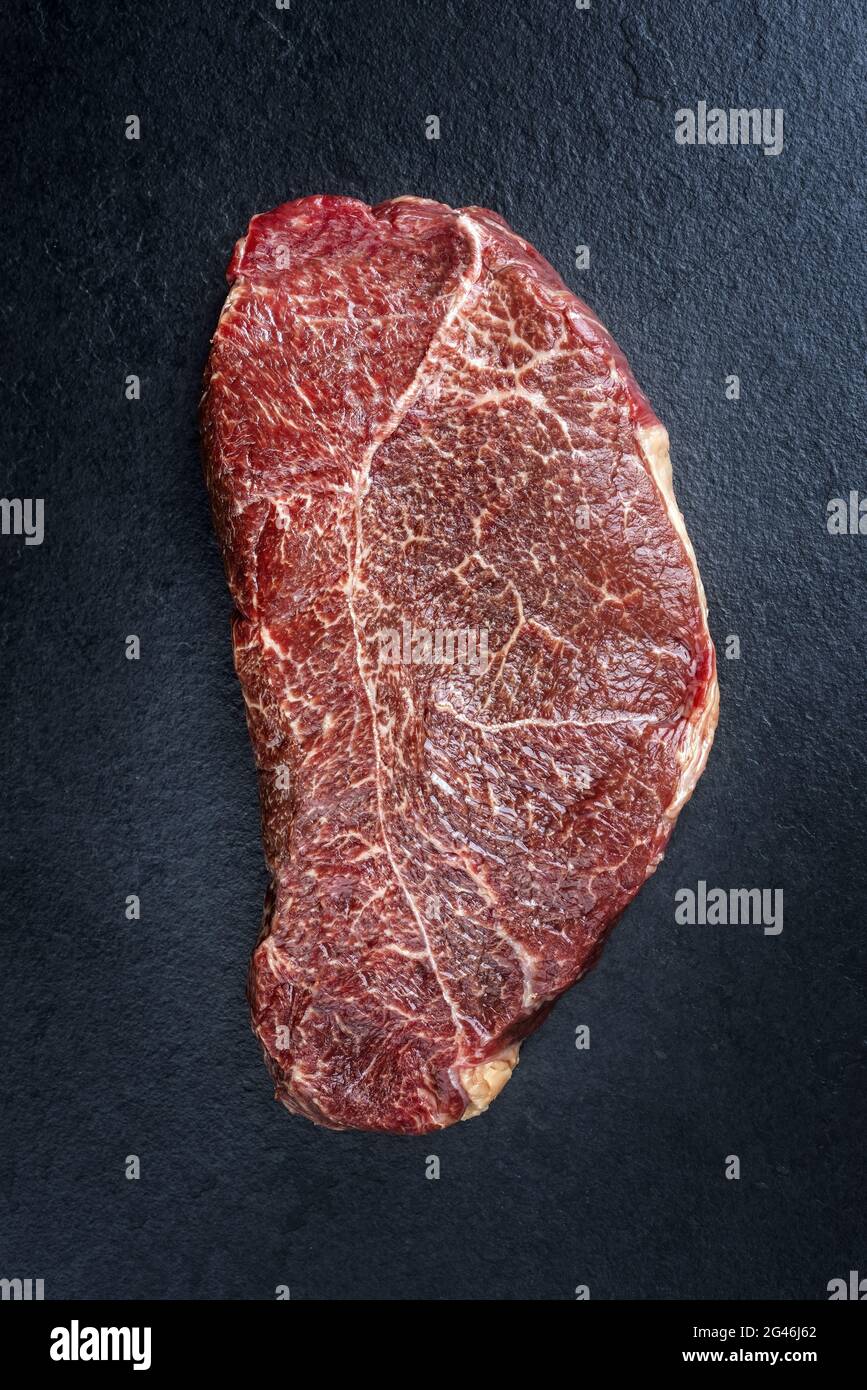 Filet traditionnel vieilli sec d'un steak de cheval naturel offert comme vue de dessus sur un tableau noir avec espace pour copier Banque D'Images