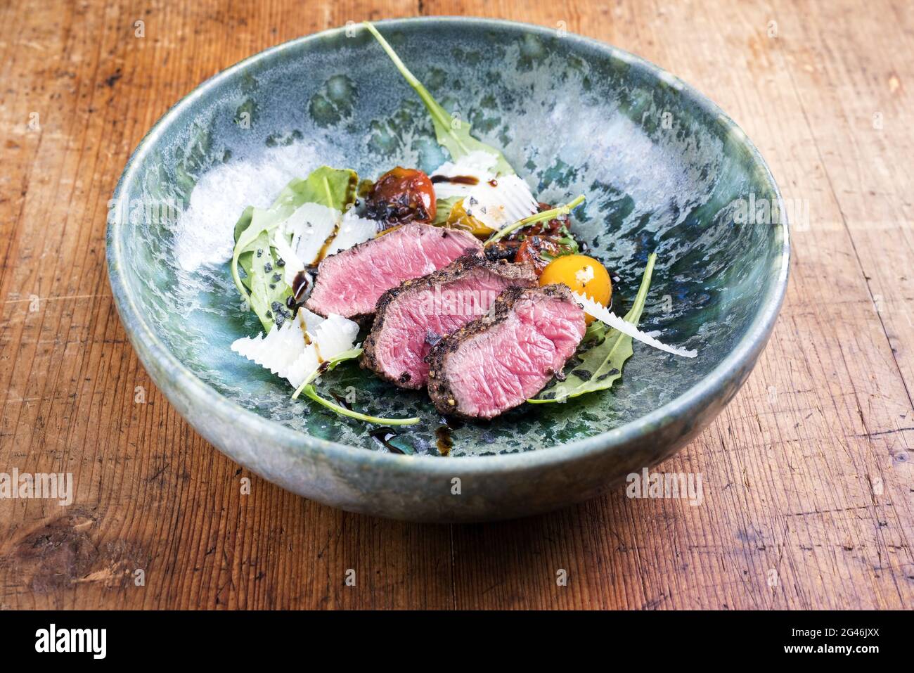 Tagliata di manzo italien de style moderne avec steak de sirloin sec et salade d'agneau servi en gros plan dans une céramique design Banque D'Images