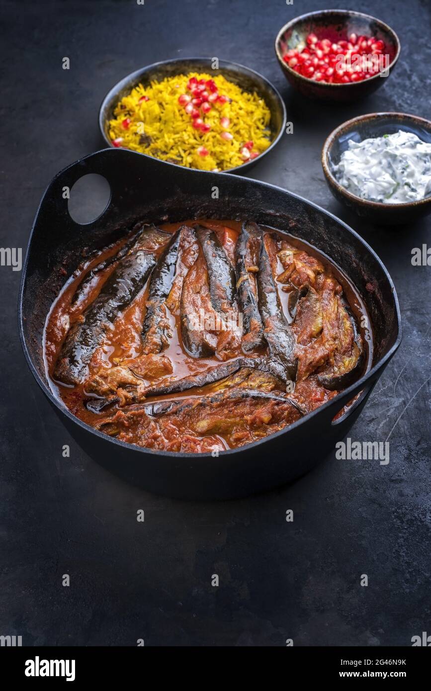 Un ragoût d'aubergines d'agneau persan lentement cuisiné de style moderne khoresh bademjan servi avec du riz et du yaourt comme vue de dessus dans un pot design Banque D'Images