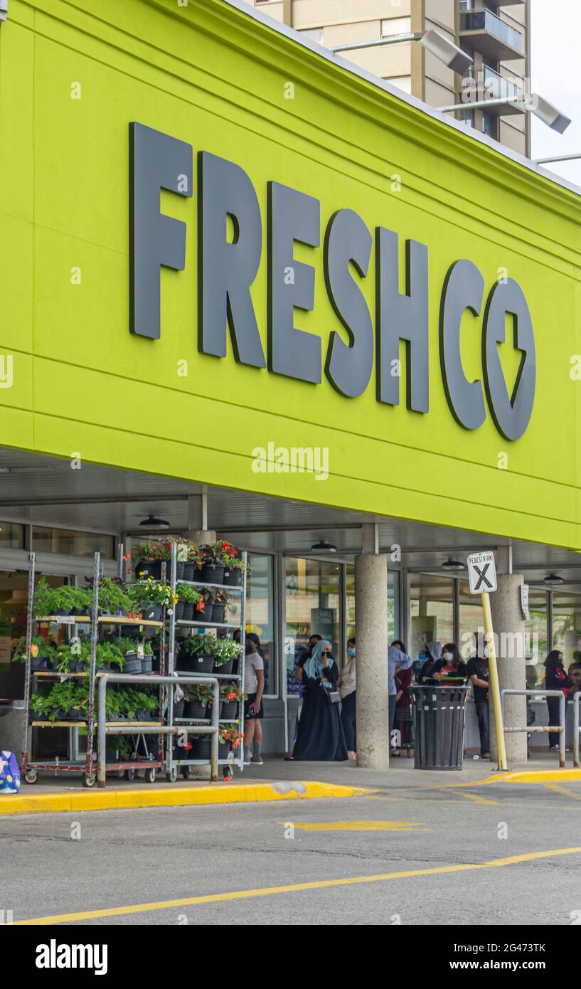 Les clients attendent à l'extérieur avant de pouvoir entrer dans l'épicerie FreshCo en raison des limites de capacité dans le magasin dans le cadre des restrictions Covid-19 Banque D'Images