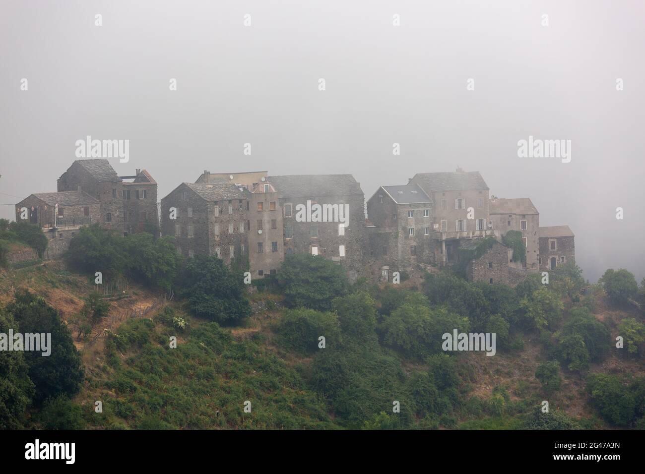 Village de montagne Corse noyé dans le brouillard. Région de Castagniccia, Corse, France Banque D'Images