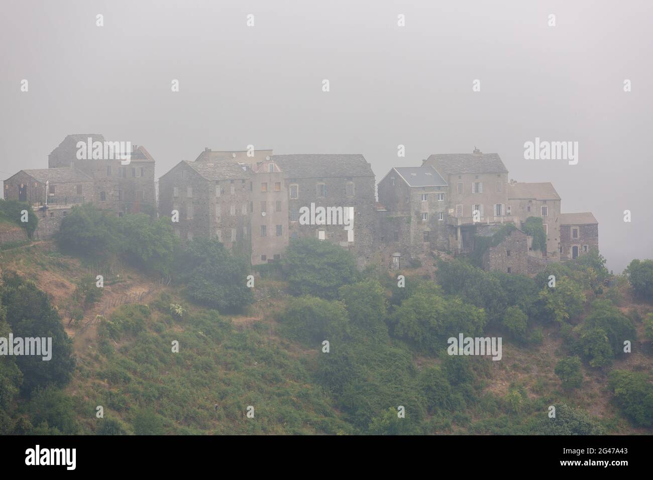 Village de montagne Corse noyé dans le brouillard. Région de Castagniccia, Corse, France Banque D'Images