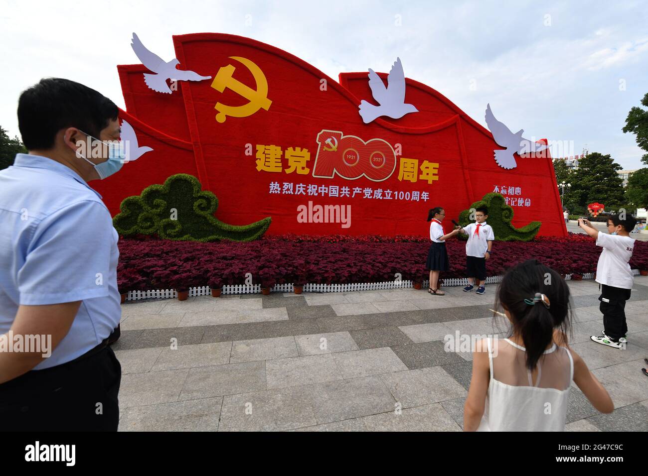 Fuyang, Chine. 19 juin 2021. Les élèves portant un foulard rouge filent des vidéos avant un signe marquant le 100e anniversaire de la fondation du Parti communiste de Chine.a l'approche du 1er juillet, toutes les parties de la Chine créent une « atmosphère intime » pour célébrer le 100e anniversaire de la fondation du Parti communiste de Chine. Crédit : SOPA Images Limited/Alamy Live News Banque D'Images