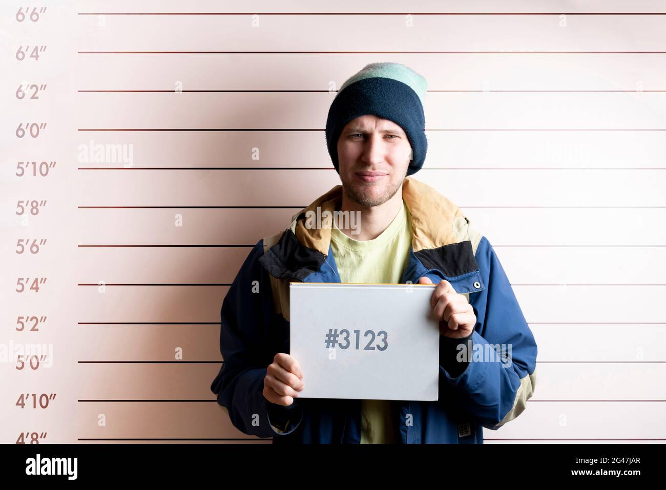 un jeune homme prisonnier arrêté tenant une carte placée devant le tableau de hauteur Banque D'Images