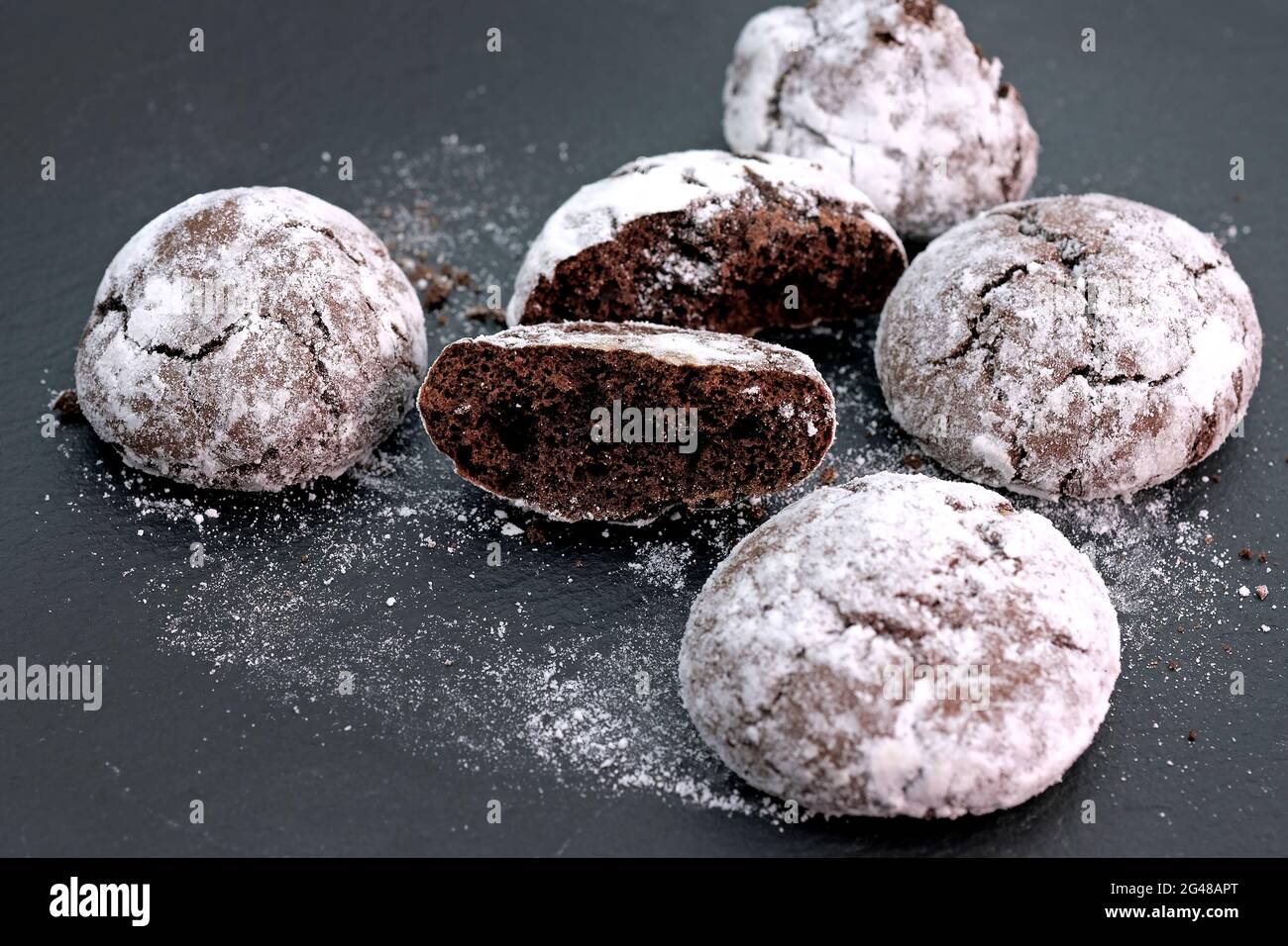 Biscuits aux pépites de chocolat saupoudrés de sucre en poudre. Biscuits ronds faits maison avec cacao et sucre en poudre sans gluten. Banque D'Images