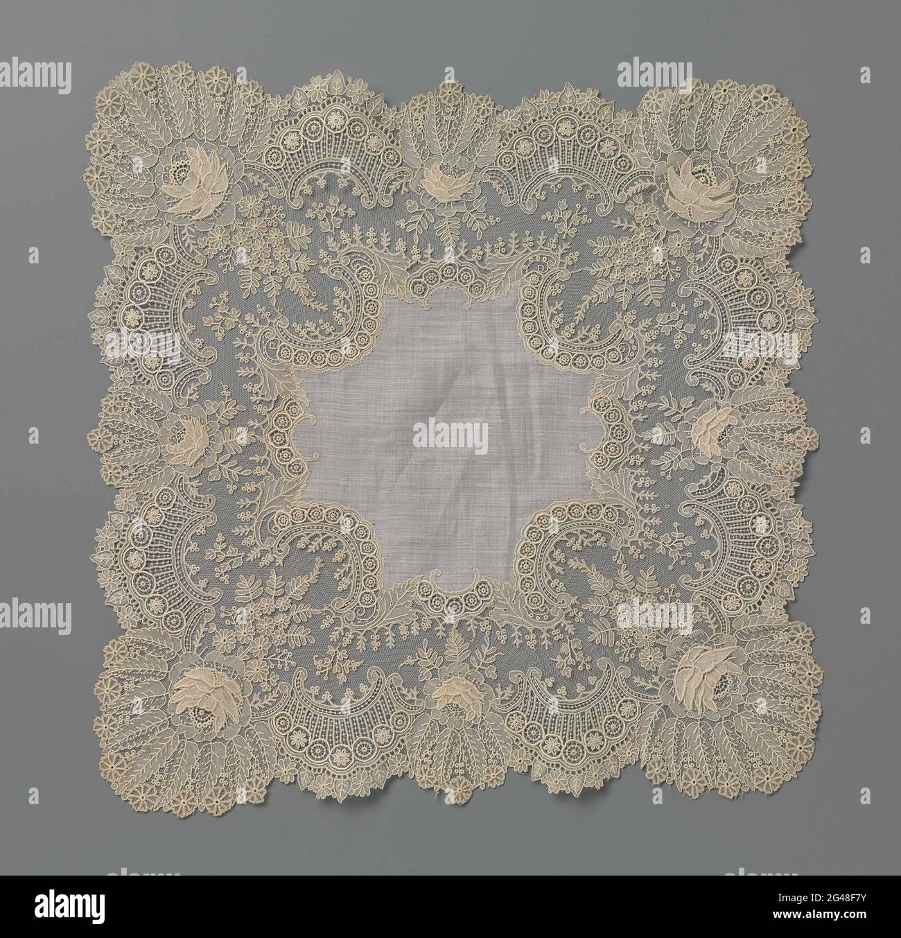 Mouchoir avec bordure de côté aiguille avec bords de roues. Mouchoir avec un bord de dentelle naturelle d'aiguille, bord de filet de Bruxelles. Pour une pièce centrale en forme de croix, un large bord à lobes s'étend. Le long des côtés extérieurs, un maillage fin est régi par du C-voluten creux avec des bords de roue, entrecoupé par des roses de relief. Le bord intérieur est formé de c-volute creux et convexe. Dans les coins se trouvent sur le filet de filet de mouches de beanies de forgetmine Banque D'Images