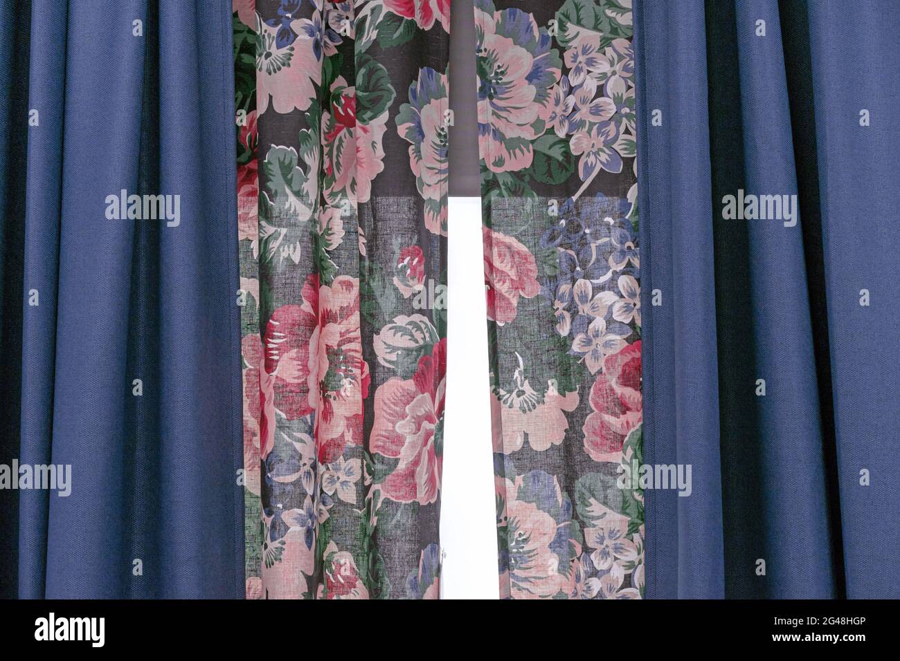 Rideaux double épaisseur en tissu bleu et tissu floral. Banque D'Images