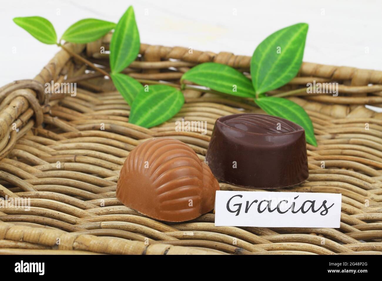 Carte Gracias (merci en espagnol) avec deux chocolats laiteux sur plateau en osier Banque D'Images