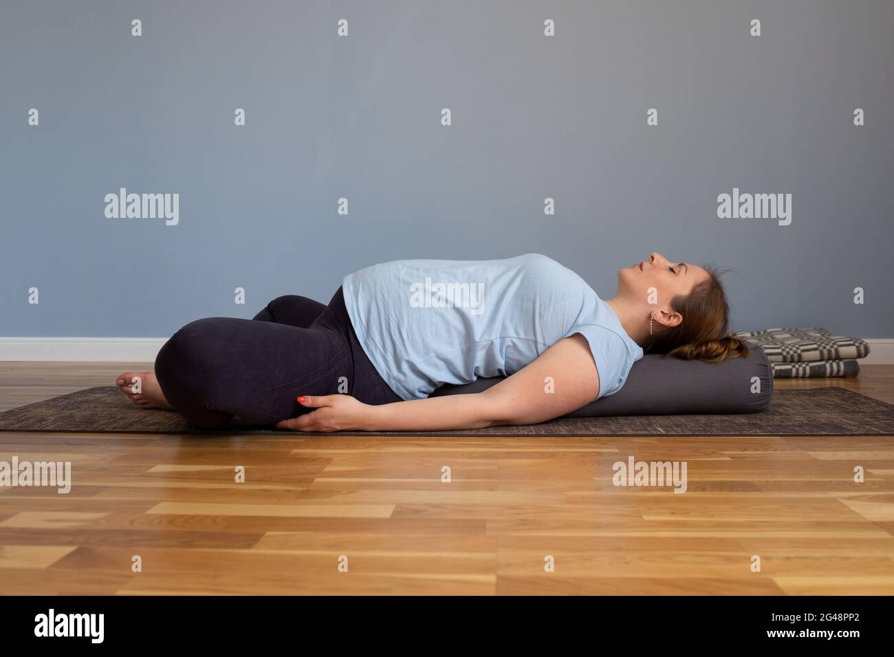 Femme enceinte pratiquant le yoga dans l'exercice de papillon incliné Banque D'Images