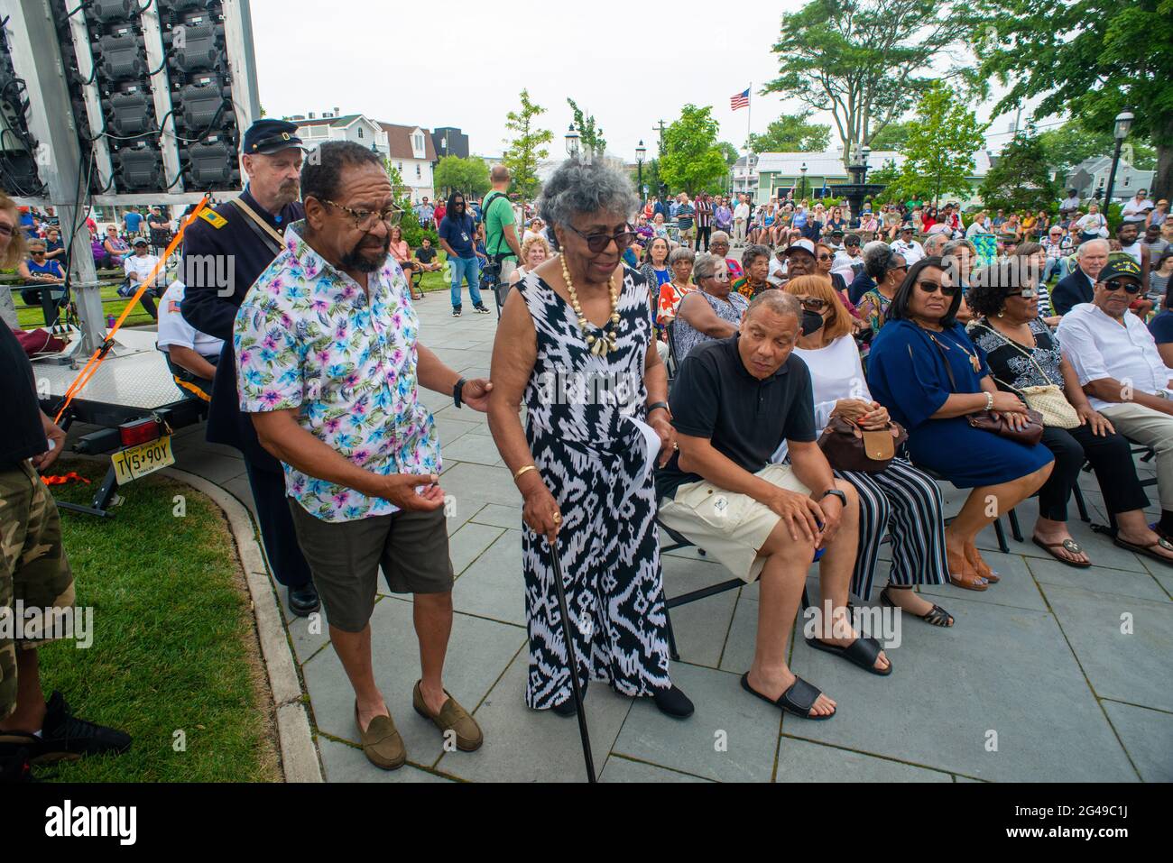 Cape May, États-Unis. 19 juin 2021. Mme Carolyn Davis, dont la famille a été la dernière à vivre à la Maison Howell comme parsonage jusqu'au milieu des années 1980, et Mme Davis a prêté des parties de la collection étendue du révérend Davis au Musée Harriet Tubman pour un certain nombre de ses expositions, Est aidé sur la scène avant de se rendre à la foule samedi, 19 juin 2021, lors de la grande célébration d'ouverture du Harriet Tubman au Rotary Park à Cape May, New Jersey. ( Credit: William Thomas Cain/Alamy Live News Banque D'Images