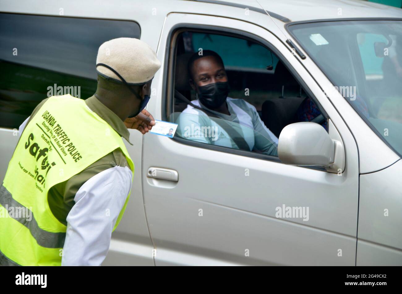 Kampala, Ouganda. 19 juin 2021. Un agent de police de la circulation vérifie les documents à un point de contrôle à Kampala, en Ouganda, le 19 juin 2021. Le Président ougandais Yoweri Museveni a annoncé vendredi une série de mesures visant à contenir la propagation rapide du nouveau coronavirus alors que le pays connaît une deuxième vague. Crédit: Nicholas Kajoba/Xinhua/Alamy Live News Banque D'Images