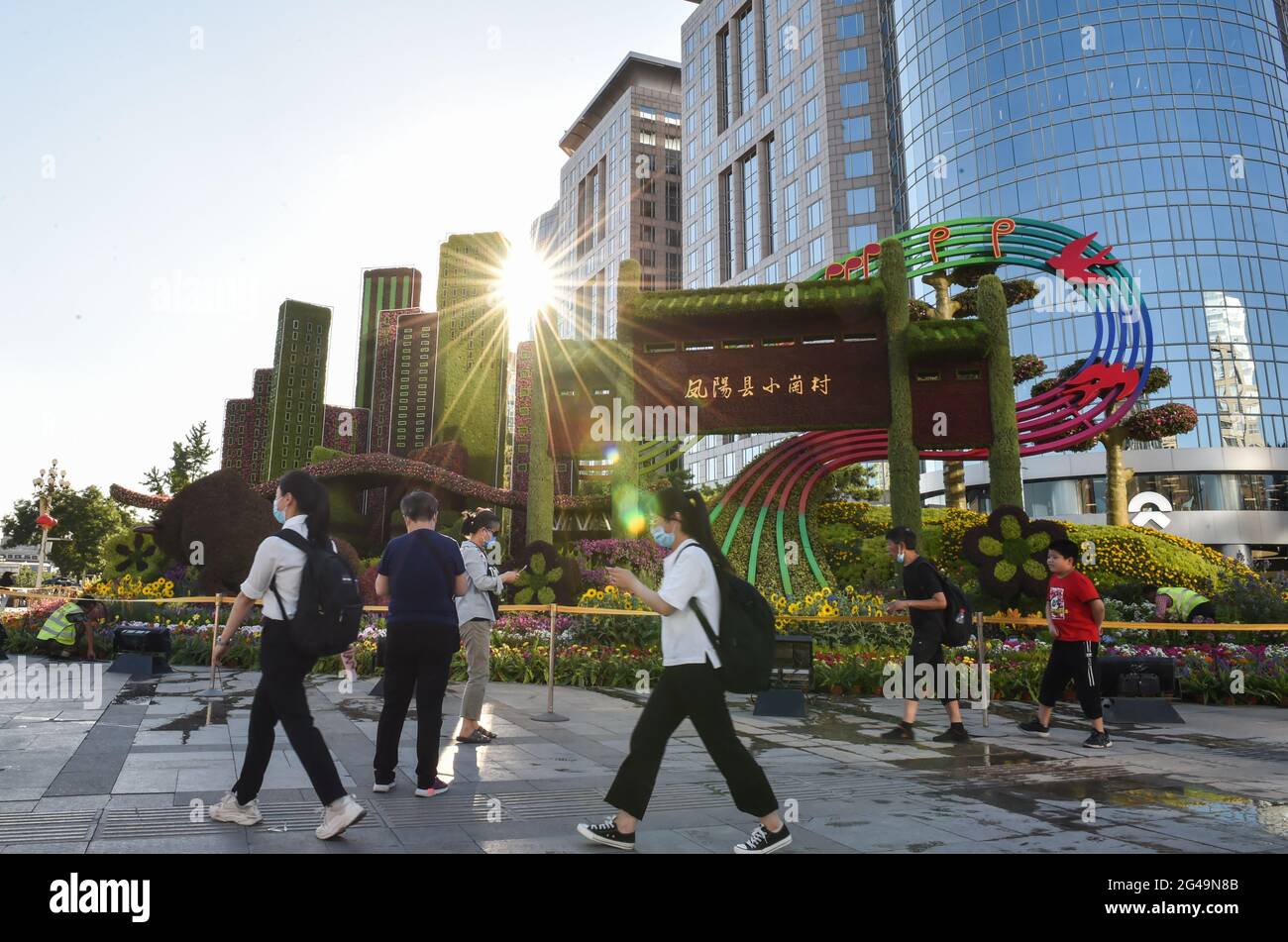 Pékin, Chine. 19 juin 2021. Les gens marchent devant des décorations florales établies le long de l'avenue Chang'an à Beijing, capitale de la Chine, le 19 juin 2021. Credit: Chen Zhonghao/Xinhua/Alay Live News Banque D'Images