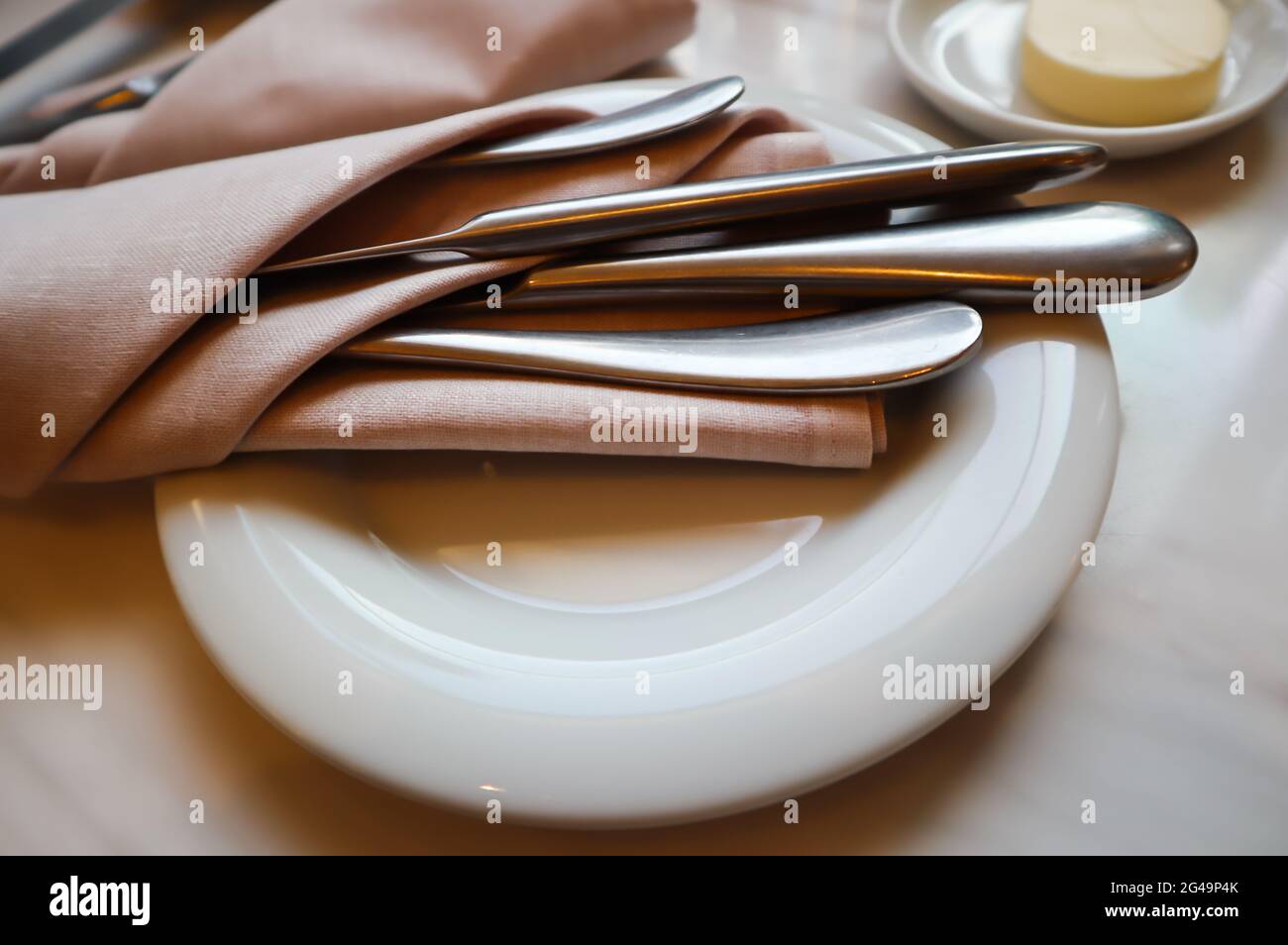 Table dans le restaurant. Assiette blanche avec couverts en serviette sur fond de marbre Banque D'Images