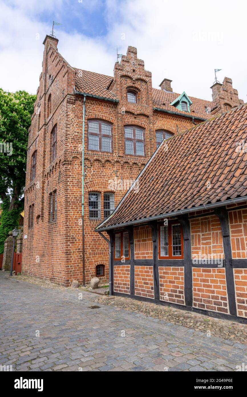 De belles maisons historiques en demi-bois et des cloisons en briques bordent une rue pavée à Ribe Banque D'Images