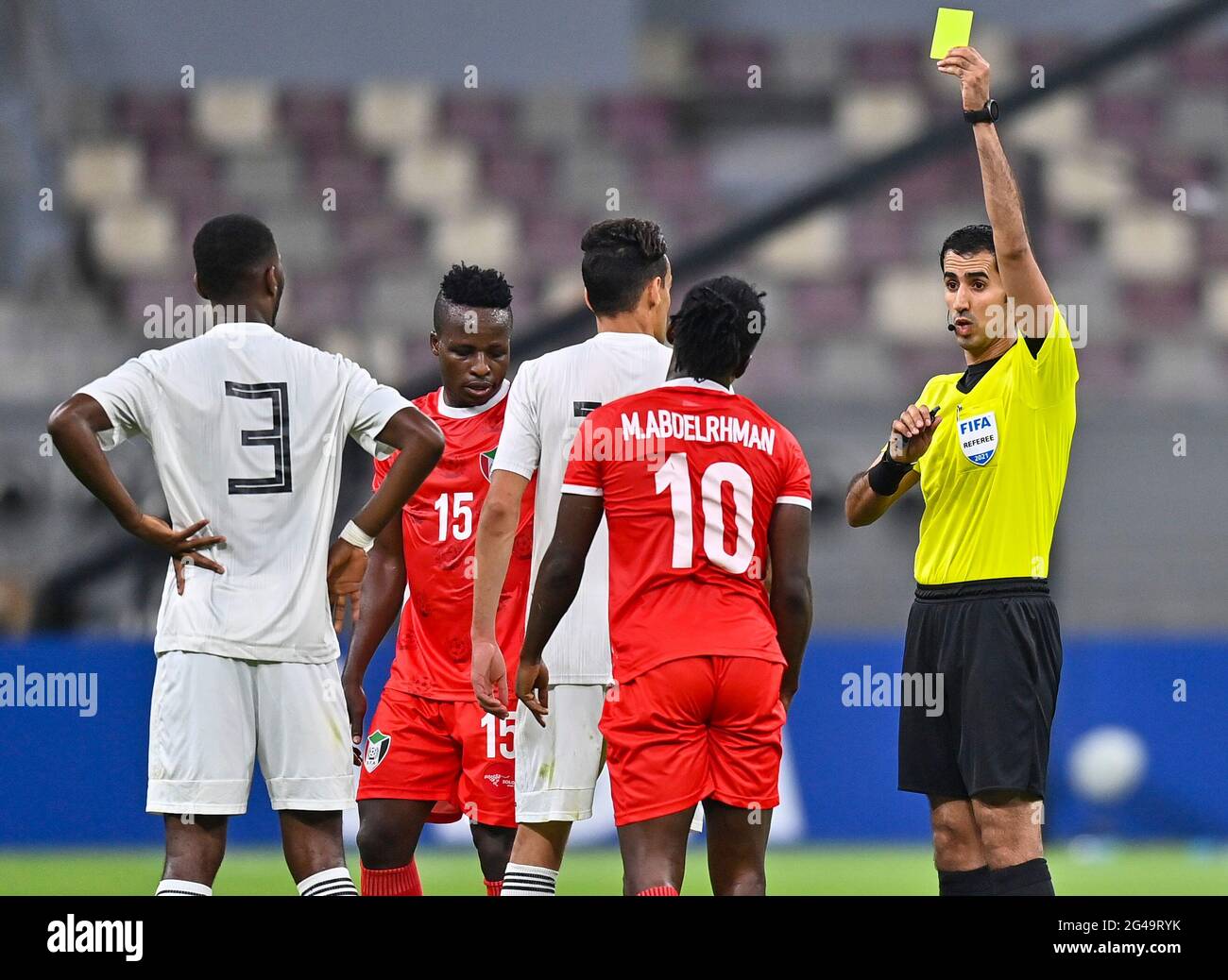 Doha, Qatar. 19 juin 2021. Saoud Al Adba, arbitre qatari (1er R), présente une carte jaune à Mohamed Abdelrhman (2e R) du Soudan lors du match de qualification de la coupe arabe de la FIFA au Qatar 2021 à Doha, Qatar, le 19 juin 2021. Credit: Nikku /Xinhua/Alay Live News Banque D'Images