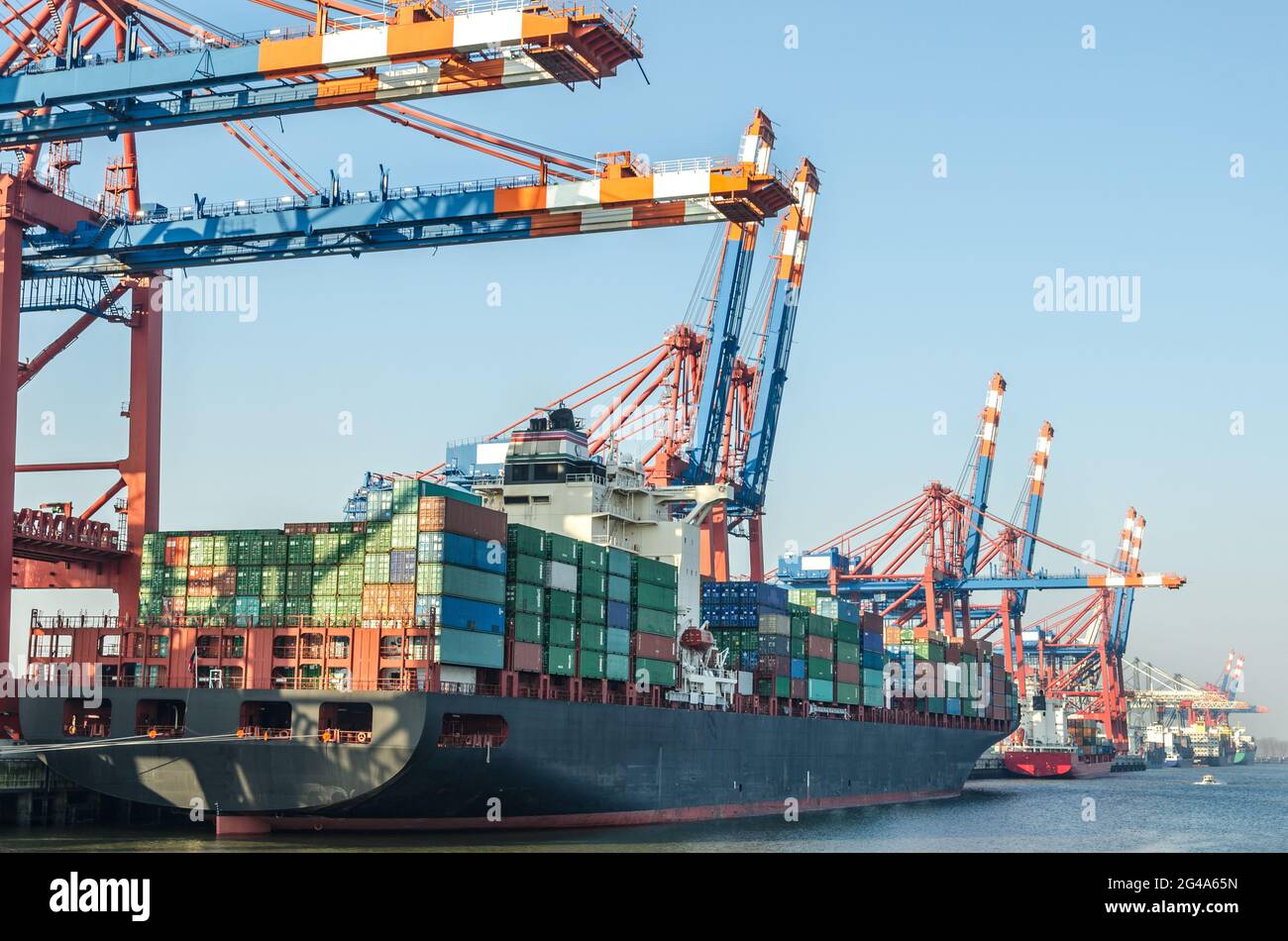 Grand navire à conteneurs et installations portuaires à un terminal à conteneurs dans la zone portuaire de Hambourg, en Allemagne Banque D'Images