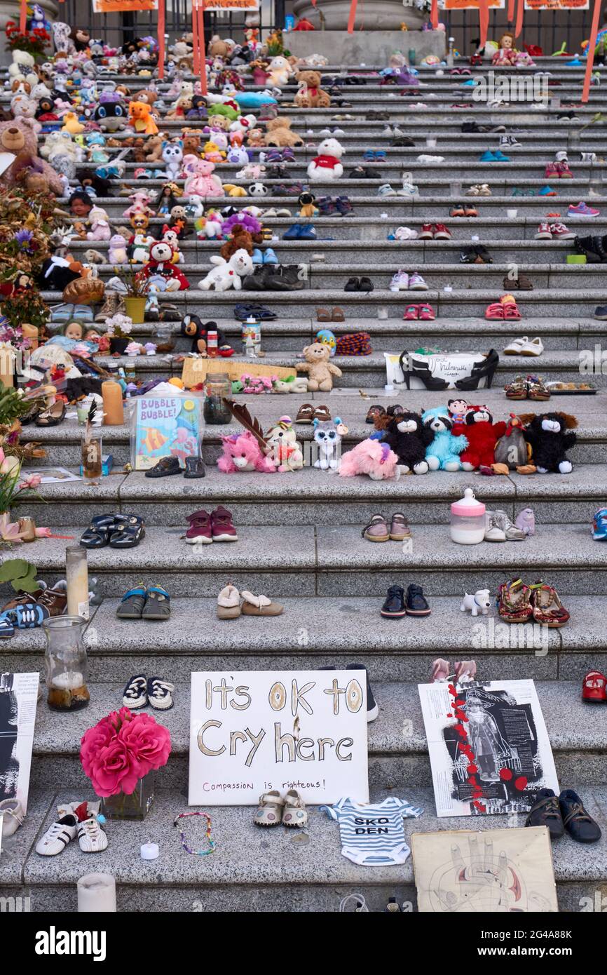 Vancouver, Colombie-Britannique, Canada. 19 juin 2021. L'installation par l'artiste haïda Tamara Bell de 215 paires de chaussures sur les marches de la Vancouver Art Gallery est devenue un sanctuaire de fortune. Cette installation rend hommage aux 215 enfants autochtones dont les tombes non marquées ont été découvertes sur les terrains d'une ancienne école résidentielle de Kamloops, en Colombie-Britannique, au Canada. Banque D'Images