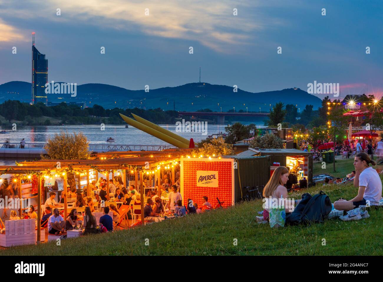 Wien, Vienne: Zone de loisirs Plage de Copa au fleuve Neue Donau (Nouveau Danube), gens sur la prairie, bar, vue sur Wienerwald et Tour du Millénaire en 22. Don Banque D'Images