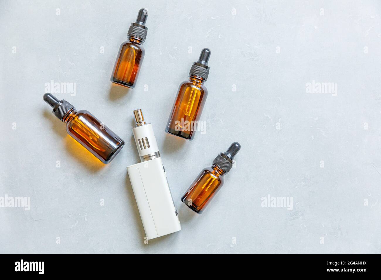Cigarettes électroniques et bouteilles de liquide de l'appareil de Vaping sur fond gris en pierre de béton. Dispositif VAPE pour fumer de substitution. Boutique Vaping Banque D'Images