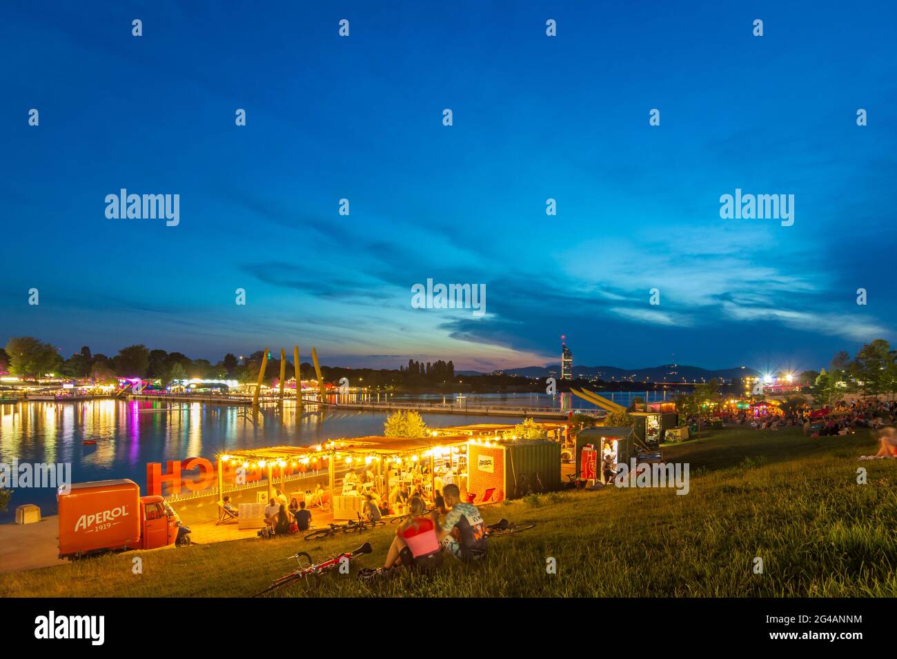 Wien, Vienne: Zone de loisirs Plage de Copa au fleuve Neue Donau (Nouveau Danube), gens sur la prairie, bar, vue sur Wienerwald et Tour du Millénaire en 22. Don Banque D'Images