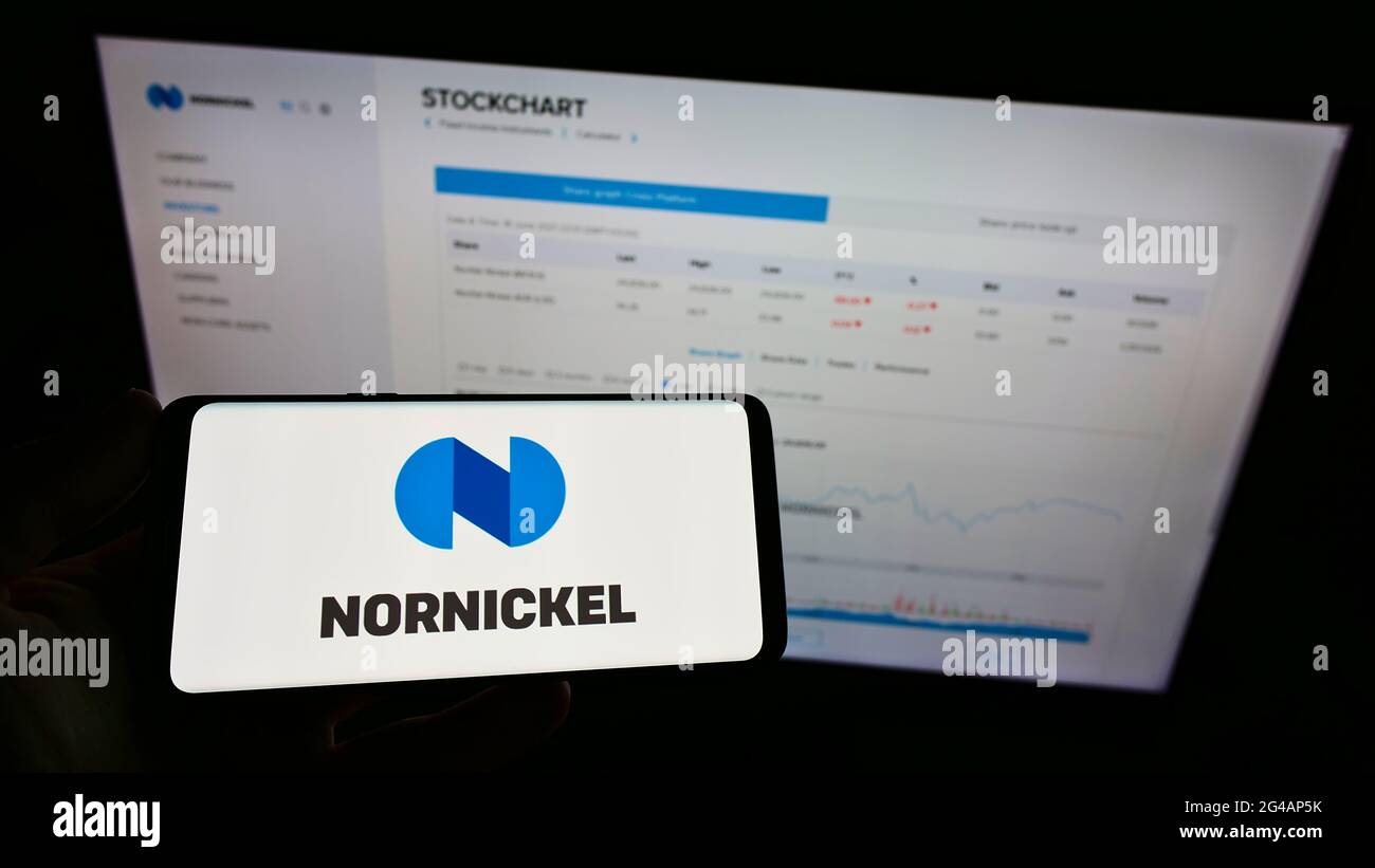 Personne tenant un smartphone avec le logo de la société minière russe Norilsk Nickel (Nornickel) à l'écran devant le site Web. Mise au point sur l'affichage du téléphone. Banque D'Images