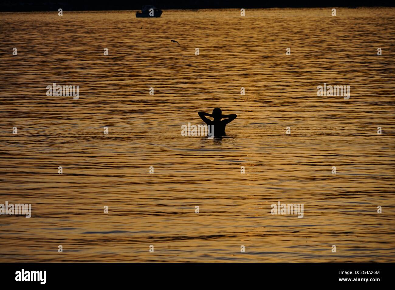 Beau coucher de soleil sur le lac Starnberg, Bavière avec une silhouette d'une femme de bain. Banque D'Images