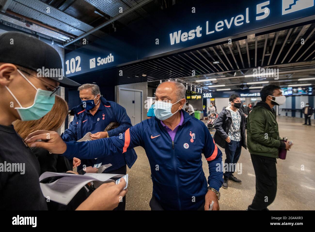 Londres, Royaume-Uni. 20 juin 2021. Les anciens joueurs de Spurs Gary Mabbutt (L) et Ossie Ardiles mettent des autocollants NHS à la disposition des personnes après leur injection de vaccin Pfizer dans un centre de vaccination de masse au stade Tottenham Hotspur, car la capitale vise 100,000 doses administrées par jour. Chelsea, West Ham et Charlton étaient d'autres clubs de football de Londres qui ont participé la veille. Credit: Stephen Chung / Alamy Live News Banque D'Images