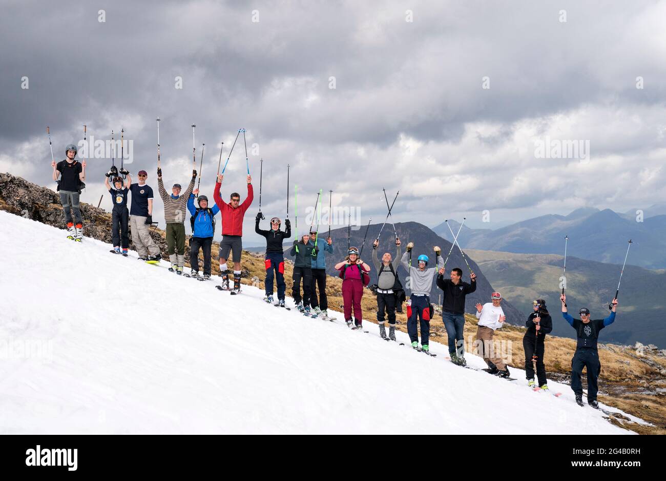 Un groupe d'environ 20 skieurs et snowboardeurs qui ont grimpé jusqu'aux restes de neige sur Meall a'Bhuiridh à Glencoe pour prendre part au ski de milieu d'été. L'événement, organisé par le Glencoe Mountain Resort, se tient chaque année le week-end le plus proche du solstice d'été. Date de la photo: Dimanche 20 juin 2021. Banque D'Images